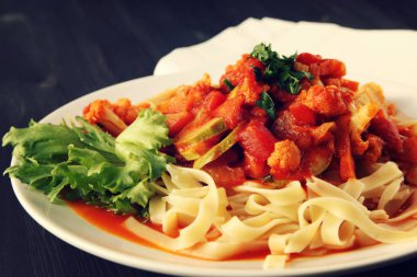 Şerit Arrabiata soslu makarna. Yakın çekim. Akdeniz çanağı. Tagliolini sebzeli makarna. Karnabahar, kabak ve domates yahnisi. İtalyan mutfağı. Vegan ve vejetaryen.