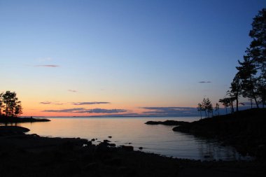 Güzel Kuzey manzara. Rus Kuzey. Gün batımında Ladoga Gölü. Vahşi doğa. Ağaçlar suya yansıyan. Retro tarzı yaşlı fotoğrafta. Yaz. Alacakaranlık. Valaam Adası, Karelya, Rusya Federasyonu.