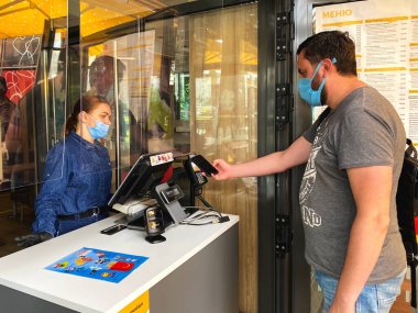 Lviv, Ukrayna - 15 Haziran 2020: McDonalds restoranı, müşteri NFC teknolojisini kullanarak ödemeyi akıllı telefonla yapıyor. İrtibatsız ve sosyal uzaklık kavramı ve ticaretin yeniden açılması