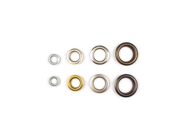 Set of brass multicoloured metal eyelets or rivets - curtains rings for fastening fabric to the cornice, isolated on white with copyspace for text for your presentation — Stock Photo, Image