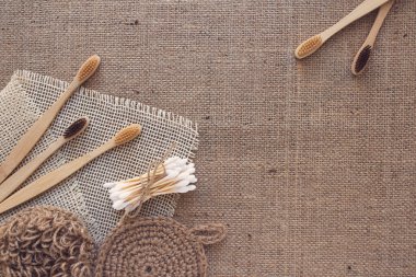 Doğal banyo ve spa aletlerinden yapılmış çerçeve, sürdürülebilir sıfır atık ve yaşam tarzı konsepti. Tahta diş fırçaları, bambu çubukları, sabun, kuru şampuan, kumaş zemin üzerinde fotokopi alanı olan diş tozu.