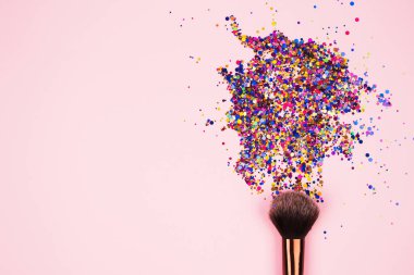 Profesyonel makyaj fırçasına yakın çekim. Parlak pembe arka planda parlak parlak parıltılar ve metin için kopyalama alanı. Yaratıcı makyaj konsepti