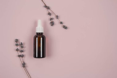 Eflatun esanslı lavanta yağı ve eflatun çiçekleri olan bir şişe ve metin için kopyalama alanı var. Model, spa ya da aromaterapi konsepti
