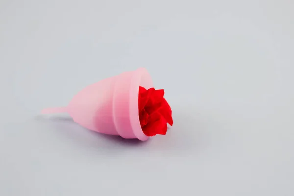 Pink menstrual cup with red flower inside on grey background with copyspace for text or creative presentation. Women health and zero waste concept. Female hygiene period products, alternative — Stock Photo, Image