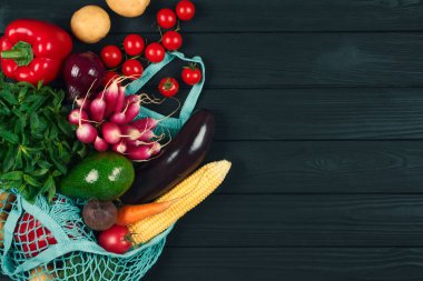 Yerel çiftçi pazarından alınmış taze sebzelerle dolu pamuk torbası. Siyah ahşap arka planda ya da masada. Sağlıklı organik gıda ve sıfır atık alışveriş konsepti. Metin veya sunumunuz için kopyalanma alanı