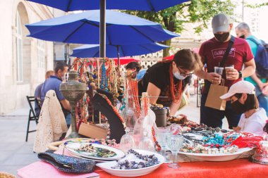Lviv, Ukrayna - 09 Ağustos 2020: Yaz garaj satışı Tlum ve Kram. Tek kullanımlık koruyucu maskeler takan, bit pazarında eski şeyleri alıp satan insanlar. Ucuz alışveriş kavramı.
