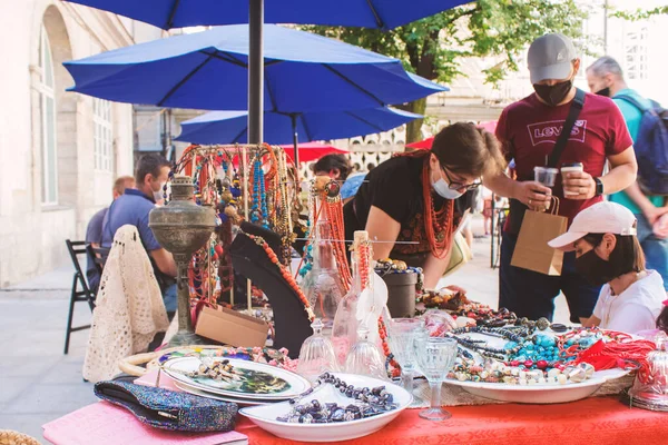 Lviv, Ukrayna - 09 Ağustos 2020: Yaz garaj satışı Tlum ve Kram. Tek kullanımlık koruyucu maskeler takan, bit pazarında eski şeyleri alıp satan insanlar. Ucuz alışveriş kavramı.
