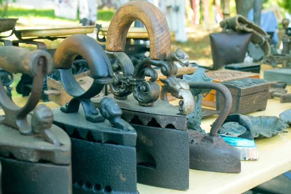 Старинные металлические угольные утюги и другие старинные предметы на блошином рынке или фестивале. Концепция коллекционных сувениров. Винтажное железо — стоковое фото