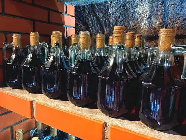 地元のワイナリーで石の棚に赤いワインボトルのモックアップイメージ 地元のワイン店で伝統的な自家製ワインやアルコールフルーツドリンク ラベルのないワインボトル 飲食観光のコンセプト — ストック写真