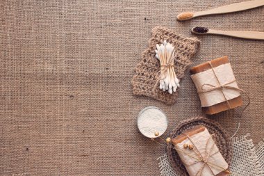 Doğal banyo ve spa aletleri seti, sürdürülebilir sıfır atık ve yaşam tarzı konsepti. Tahta diş fırçaları, bambu çubukları, sabun, kuru şampuan, kumaş zemininde fotokopi alanı olan diş pudrası. Model