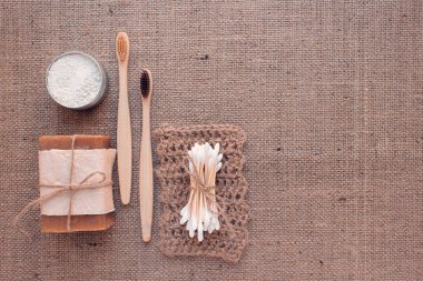 Doğal banyo aletleri, sürdürülebilir sıfır atık ve yaşam tarzı konsepti. Ahşap diş fırçaları, bambu bezleri, sabun, diş tozu ve el yapımı jüt çamaşırları.