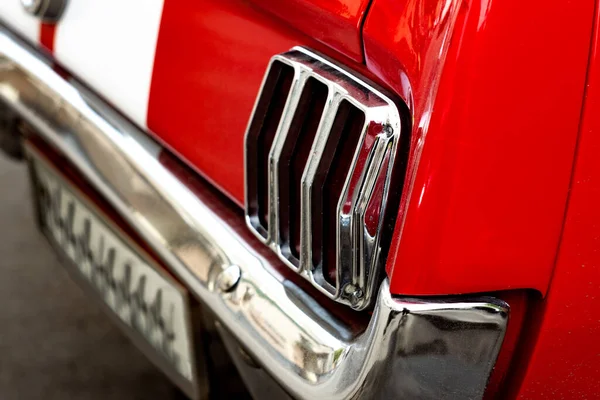 Faros traseros cromados de un coche retro rojo. Vehículo vintage con líneas blancas y un parachoques de metal. Afinación moderna . — Foto de Stock