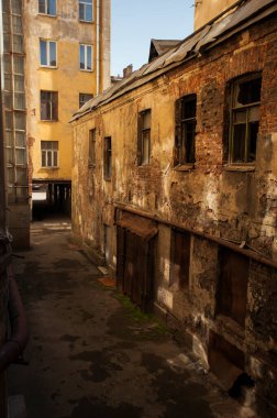 St. Petersburg 'daki eski avluda. - Rusya. Kırmızı tuğlalı evler. Güneş ışığı. Kabartmalı pencereler.