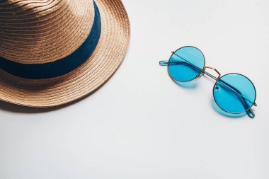 Yaz şapkası ve mavi güneş gözlüğü. Sıcak mevsimde dinlenmek için yaz seti. Deniz, kum ve güneş.