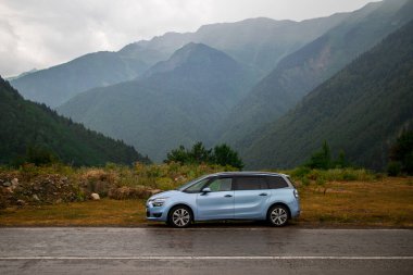 Dağlarda büyük bir aile arabası. Off-road konsept geçmişi. Yaz tatili. Citroen Grand C4 Picasso. 14 Ağustos 2017. Georgia mı? Editör fotoğrafı.