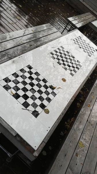 Halka açık bir parkta satranç tahtaları Tahta bir masanın üzerinde oyunlar.