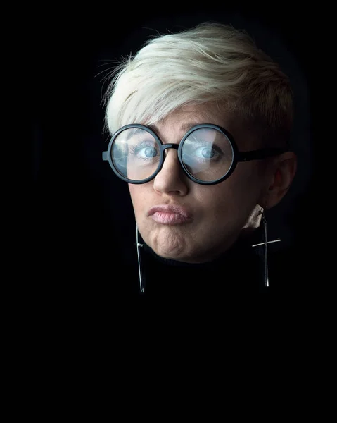 Porträtt av en kvinna med glasögon, som gör en grimas — Stockfoto
