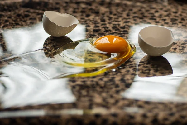 Zerbrochenes Ei mit Eigelb, Eiweiß und Schale auf Leopardenhaut — Stockfoto