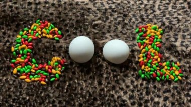 renkli şeker ve yumurta leopar desen arka planda kelime serin bulunmakta