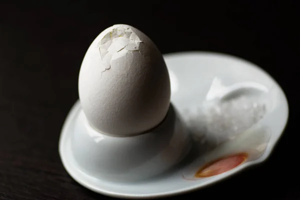 Huevo cocido roto con cuchara, de pie y sal en la oscuridad — Foto de Stock