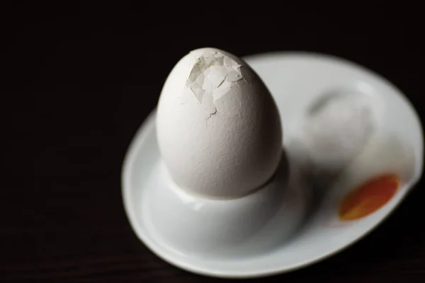 Oeuf bouilli cassé avec cuillère, stand et sel sur fond sombre — Photo