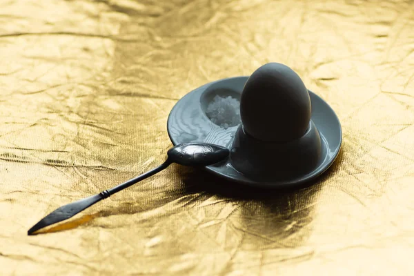 Huevo cocido con cuchara, pie y sal sobre oro — Foto de Stock
