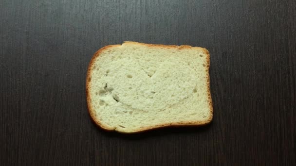 Een Stuk Brood Gesneden Hart Tegen Een Donkere Plank — Stockvideo