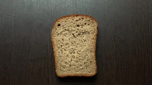 Een Stuk Brood Gesneden Hart Tegen Een Donkere Plank — Stockvideo