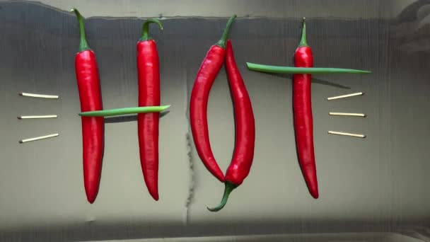 Pimiento picante rojo y cebollas presentaron la palabra caliente en la superficie del espejo — Vídeo de stock