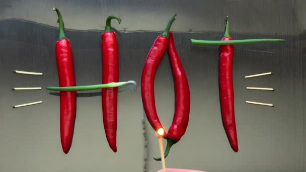 Červené pálivé papriky a cibule rozloženy slovo horké na povrchu zrcadla — Stock video