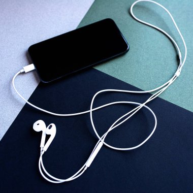 bir keman anahtarı şeklinde kulaklıklar ile cep telefonu