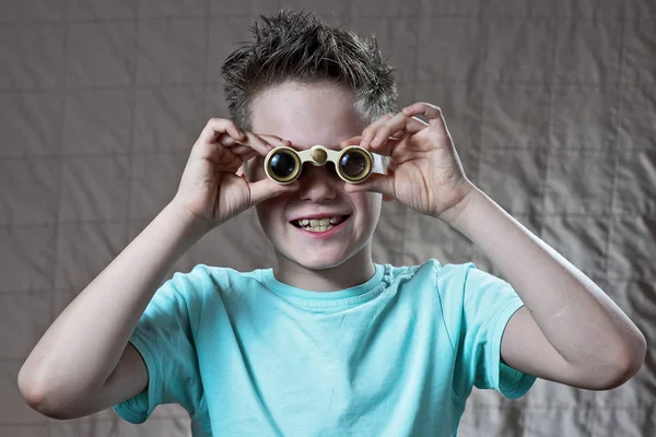 Sorprendido adolescente chico emocionalmente mirando a través de binoculares — Foto de Stock