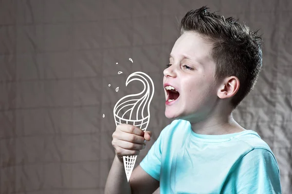 Dreng i en let t-shirt spiser malet is, hvorfra flyvende spray - Stock-foto