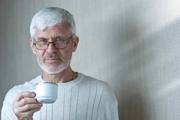 커피 한 잔을 들고 있는 회색 머리남자의 초상화 — 스톡 사진