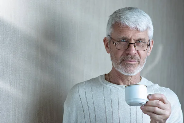 커피 한 잔을 들고 있는 회색 머리남자의 초상화 — 스톡 사진