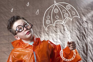 turuncu bir yağmurluk ve boyalı şemsiye ile çocuk yağmur standları