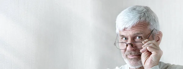 Gray-haired man in light clothes and glasses enters into a contract on paper — Stock Photo, Image