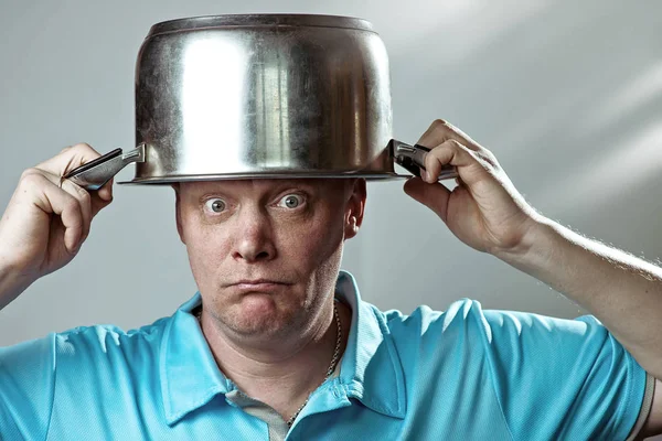 Un hombre calvo y brutal con camiseta azul se puso una olla en la cabeza — Foto de Stock