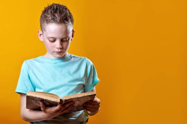 renkli bir arka plan üzerinde bir kitap tutan hafif bir t-shirt neşeli çocuk