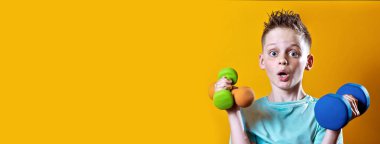 sarı bir arka plan üzerinde dumbbells ile parlak bir t-shirt bir çocuk