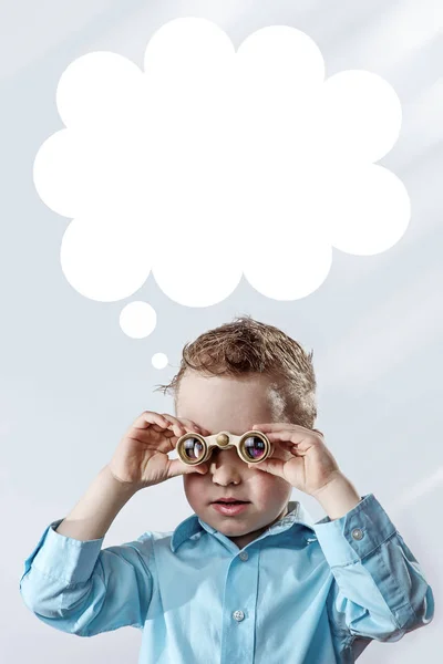 Boy in a light shirt looking through binoculars on a light background — Stock Photo, Image
