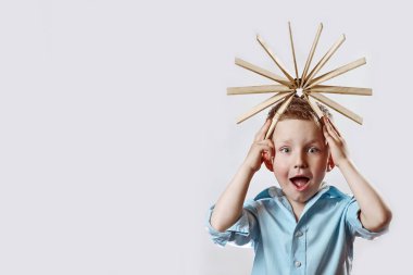 mavi gömlek li bir çocuk şaşırttı ve parlak arka planda kafasına sürücü