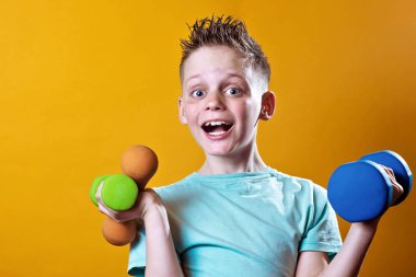 sarı bir arka plan üzerinde dumbbells ile parlak bir t-shirt bir çocuk