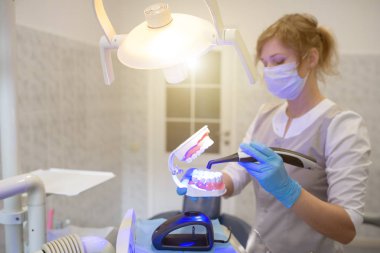 Doktor nasıl modern bir fotoğraf polimerizasyon lambası kullanmak için çene gösterir