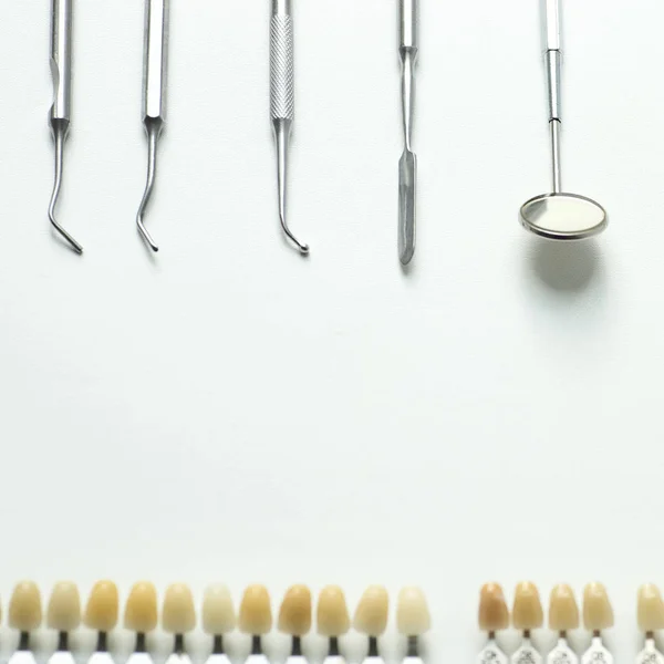 Una serie de herramientas dentales colocadas planas sobre un fondo claro —  Fotos de Stock
