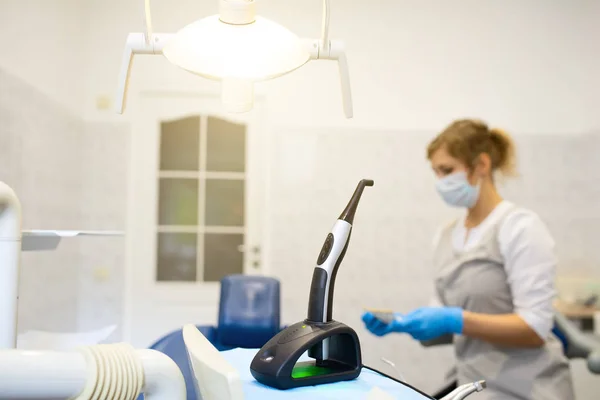 En moderne fotopolymerisationslampe til lette fyldninger på tandkontoret på en sløret baggrund - Stock-foto