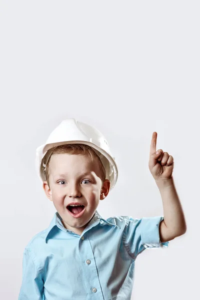 Boy in the light blue shirt and construction helmet of the foreman raised a finger, as if he had found the idea — Stock Photo, Image