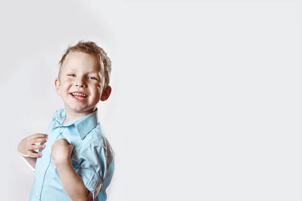 A smiling happy boy in blue shirt on light background — Stock Photo, Image