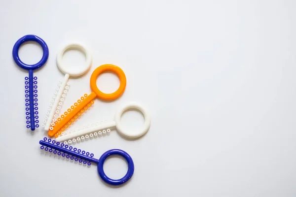 Una ligadura ortodóncica multicolor para alinear los dientes del ortodoncista sobre un fondo claro — Foto de Stock