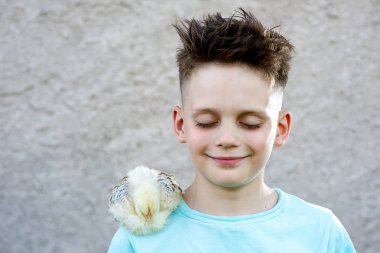kabarık tavuk ile mavi bir t-shirt çocuk gözlerini kapattı ve bulanık bir arka plan üzerinde rüya.